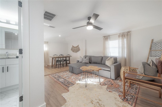 living room with ceiling fan and light hardwood / wood-style floors