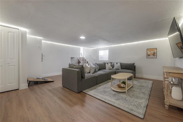 living room with a textured ceiling and dark hardwood / wood-style flooring