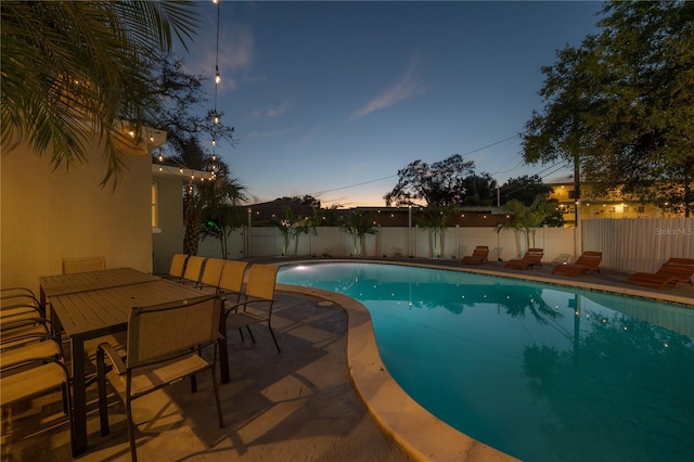 view of pool at dusk