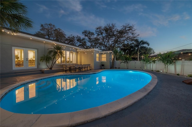 pool at dusk with a patio area