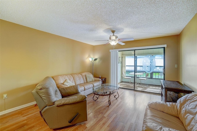 living room featuring a textured ceiling, light hardwood / wood-style flooring, and ceiling fan