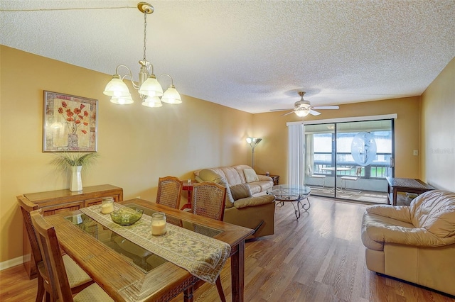 living room with hardwood / wood-style flooring, ceiling fan with notable chandelier, and a textured ceiling