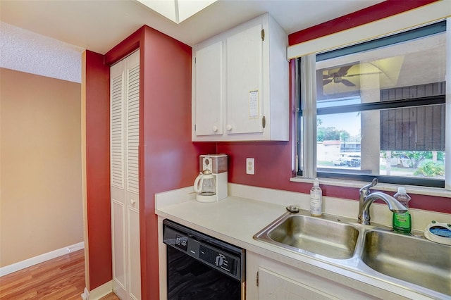 kitchen with dishwasher, white cabinets, light hardwood / wood-style flooring, and sink