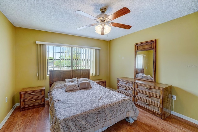 bedroom with wood-type flooring, a textured ceiling, and ceiling fan