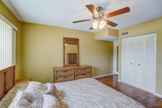 bedroom featuring ceiling fan, a closet, wood-type flooring, and a textured ceiling