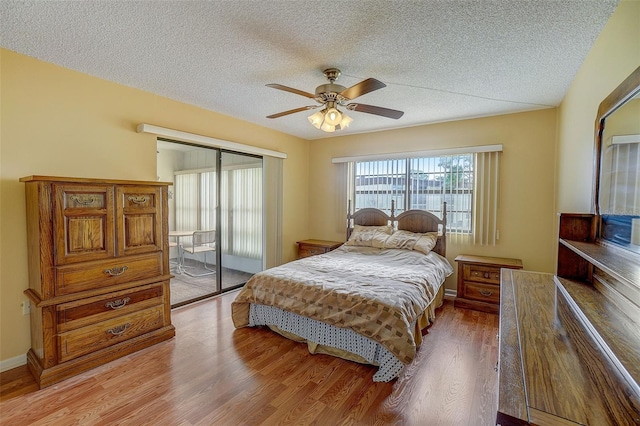 bedroom with a textured ceiling, hardwood / wood-style flooring, and ceiling fan