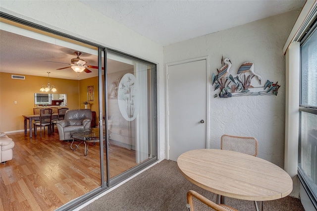 interior space with ceiling fan with notable chandelier