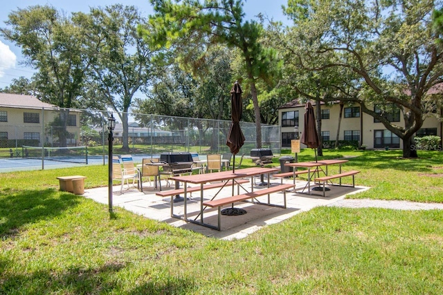 surrounding community featuring a lawn and tennis court