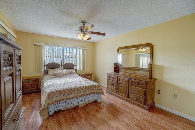 bedroom featuring ceiling fan, a textured ceiling, and light wood-type flooring