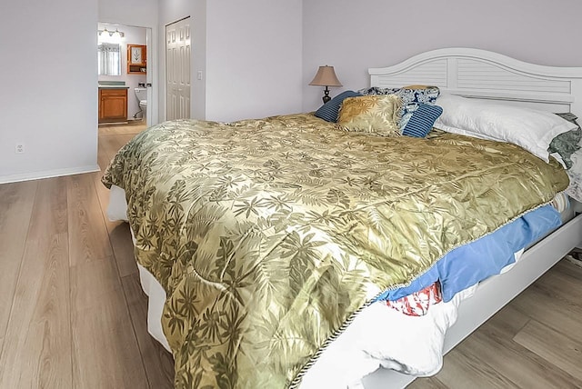 bedroom featuring hardwood / wood-style floors and ensuite bath