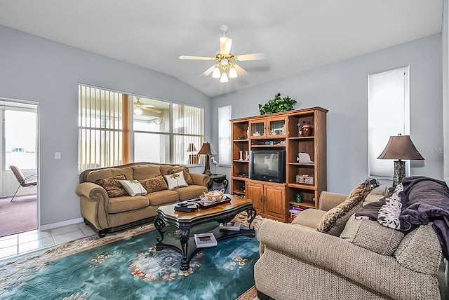 living room featuring ceiling fan, light tile patterned flooring, and vaulted ceiling