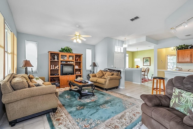 living room with ceiling fan, light tile patterned floors, and track lighting