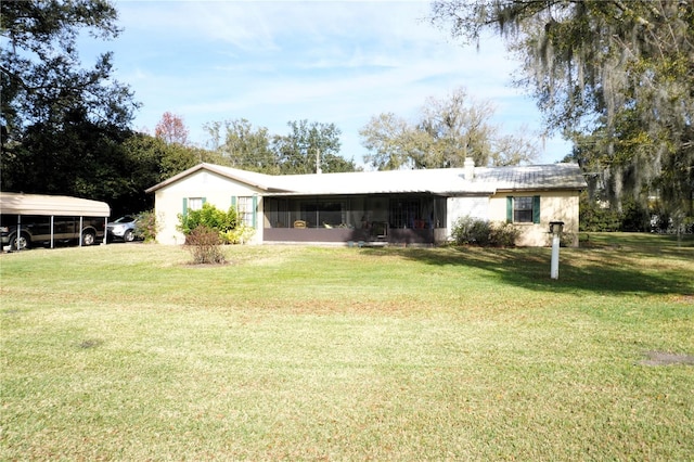 rear view of house with a lawn and a carport