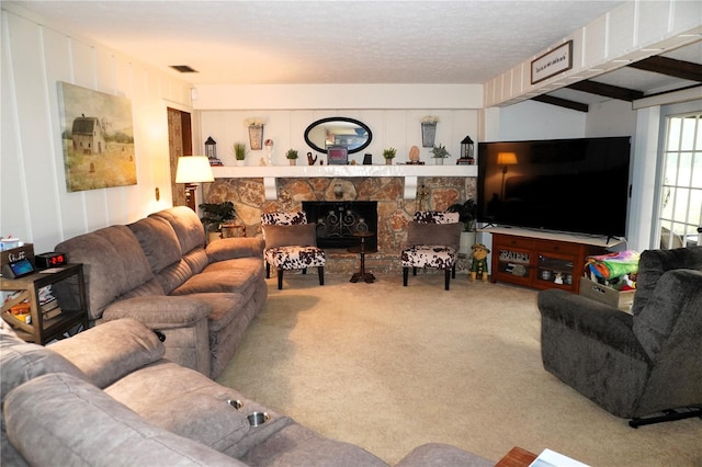 living room featuring beamed ceiling, carpet floors, and a fireplace