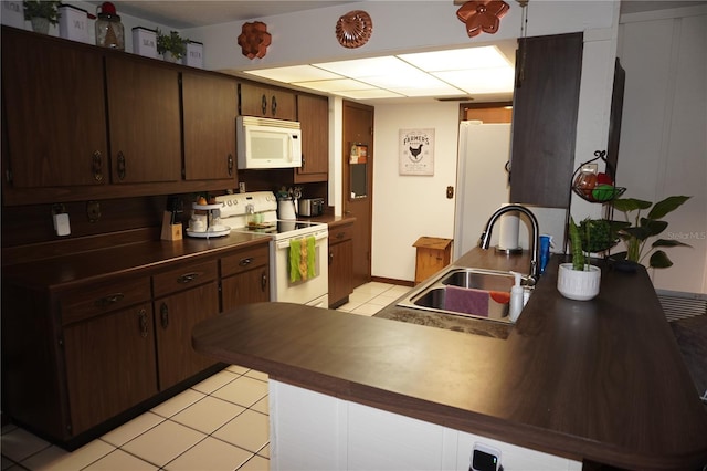 kitchen with white appliances, light tile flooring, sink, and dark brown cabinetry