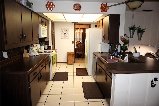 kitchen with white appliances, sink, dark brown cabinets, and light tile floors