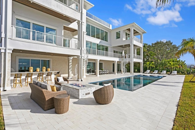 view of swimming pool with an outdoor living space with a fire pit and a patio area