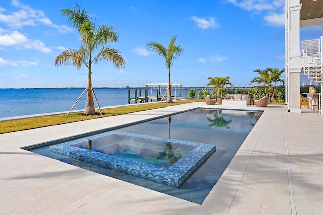 view of pool featuring a water view, a patio, and an in ground hot tub