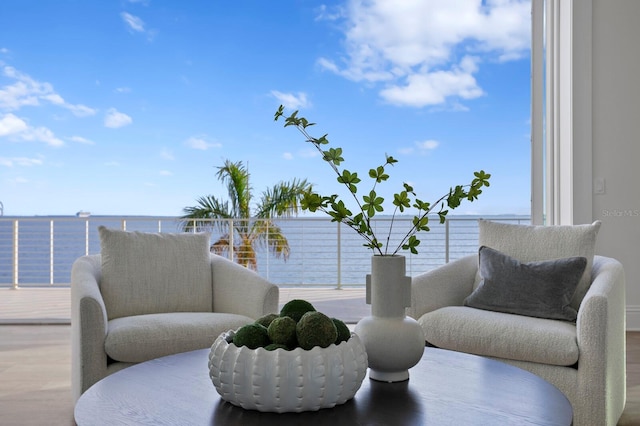 sitting room featuring a water view and hardwood / wood-style flooring