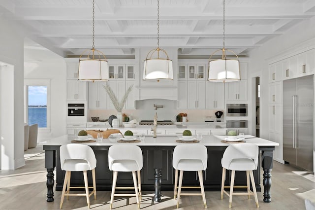 kitchen featuring beamed ceiling, a water view, a large island, and stainless steel appliances