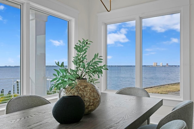 dining area with a wealth of natural light and a water view