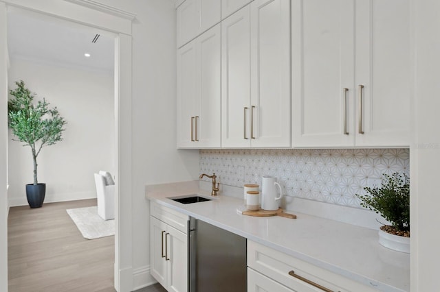 bar with white cabinetry, sink, and decorative backsplash