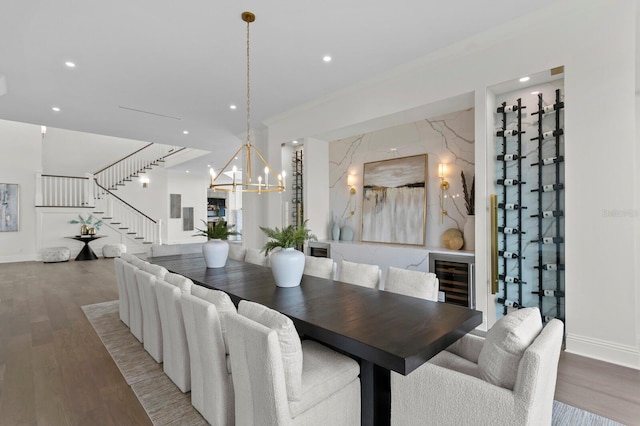 dining room with wine cooler, an inviting chandelier, and hardwood / wood-style floors