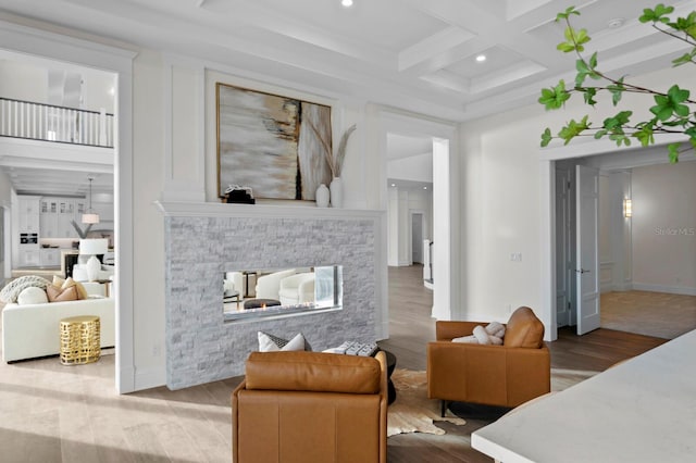 bedroom with a stone fireplace, coffered ceiling, wood-type flooring, and beamed ceiling