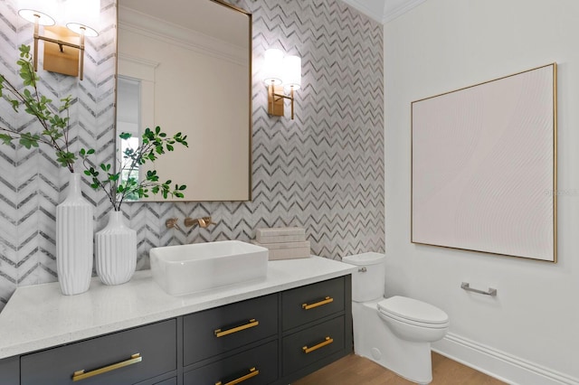 bathroom with vanity, toilet, and crown molding