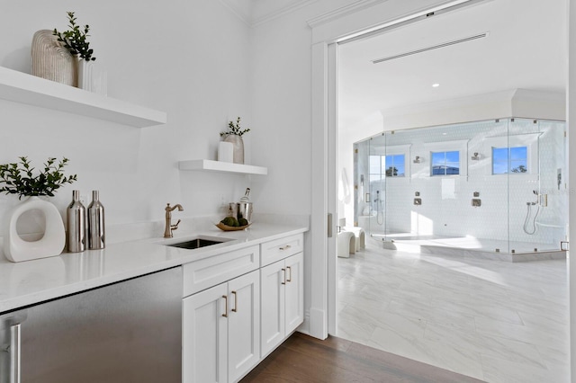 bar with dark hardwood / wood-style floors, white cabinetry, sink, and ornamental molding