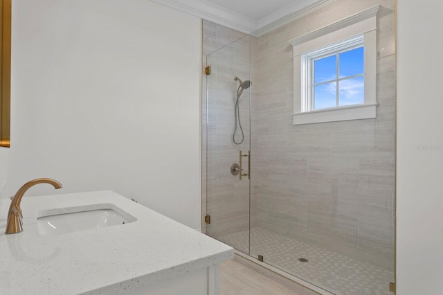 bathroom featuring walk in shower, vanity, and crown molding