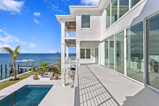 view of swimming pool with an outdoor hangout area, a patio area, a water view, and a boat dock