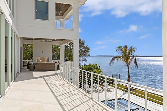 balcony with a water view, ceiling fan, and an outdoor hangout area