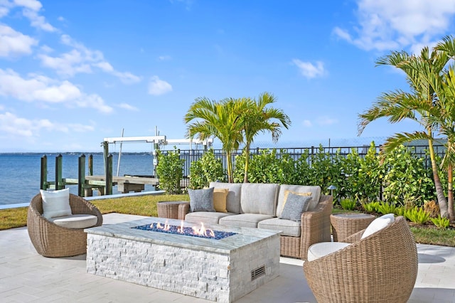 view of patio / terrace with a water view, an outdoor living space with a fire pit, and a boat dock