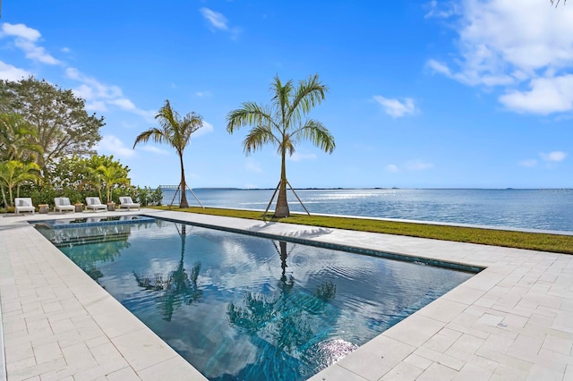 view of swimming pool with a water view and a patio area