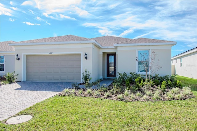 single story home featuring a garage and a front lawn