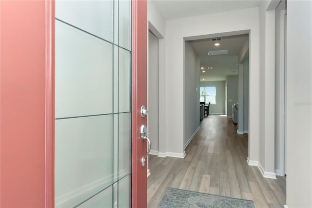 hallway with light hardwood / wood-style floors