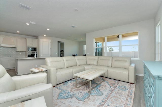 living room featuring light wood-type flooring and ceiling fan