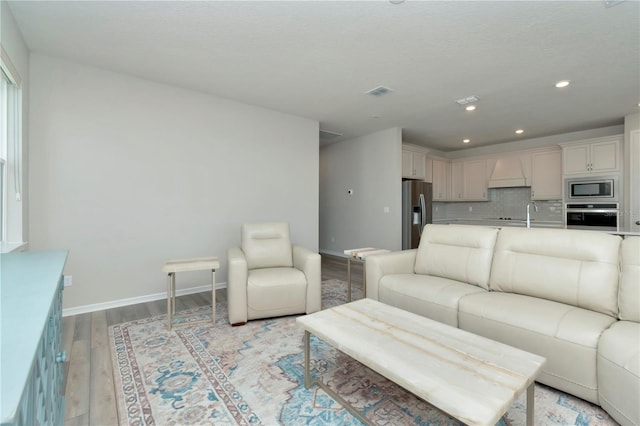 living room with sink and light hardwood / wood-style floors