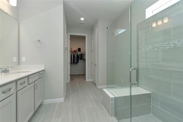 bathroom featuring walk in shower, tile patterned floors, and vanity