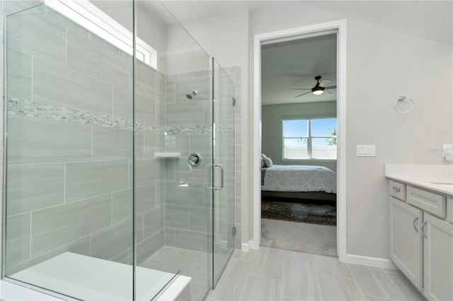 bathroom with a shower with shower door, vanity, ceiling fan, and tile patterned flooring