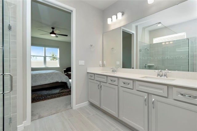 bathroom featuring a shower with shower door, tile patterned floors, double sink vanity, and ceiling fan