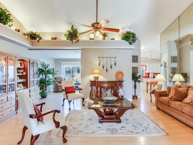 living room featuring high vaulted ceiling, light hardwood / wood-style floors, and ceiling fan