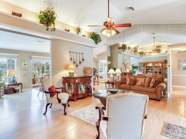 living room with high vaulted ceiling, ceiling fan, and light wood-type flooring