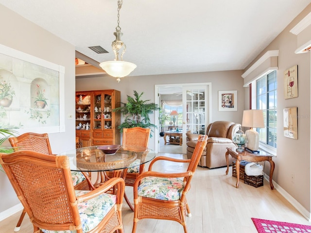 dining room with light hardwood / wood-style floors and french doors