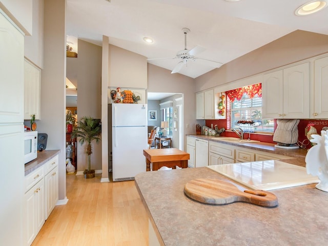 kitchen featuring white appliances, sink, ceiling fan, white cabinetry, and lofted ceiling