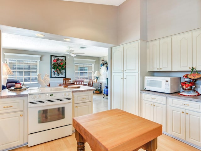 kitchen featuring ceiling fan, white appliances, and white cabinetry