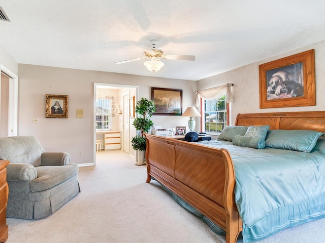 bedroom with ensuite bath, ceiling fan, and light colored carpet