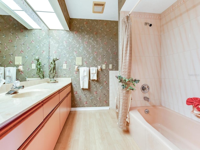 bathroom featuring oversized vanity, wood-type flooring, and shower / bath combo with shower curtain