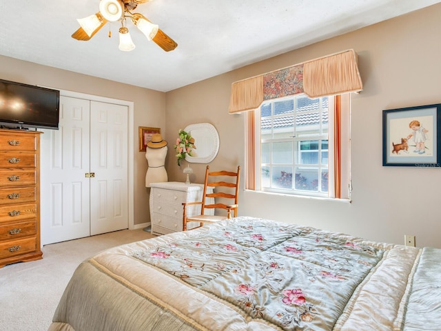 bedroom featuring light carpet, a closet, and ceiling fan